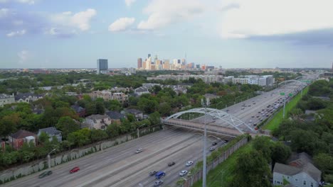 Aerial-view-of-affluent-neighborhood-near-freeway-with-downtown-Houston-in-the-background