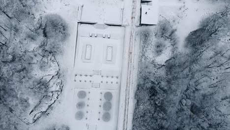 Birds-eye-view-from-drone-flying-over-the-Gunnebo-palace-and-garden-covered-in-snow