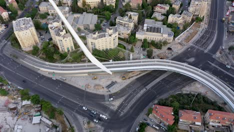 Aerial-tilt-down-shot-over-the-Chords-Bridge,-car-at-the-intersection,-Jerusalem-Israel