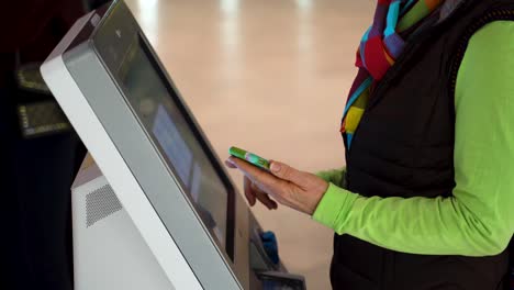 Closeup-of-woman-holding-smartphone-and-doing-a-self-check-in-at-the-airport