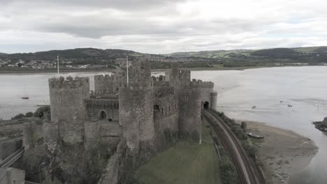 Aerial-view-above-Conwy-castle-Welsh-medieval-town-historic-landmark-push-in-orbit-right