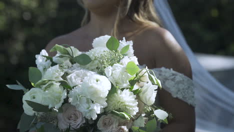 Gentle-breeze-blows-while-bride-holds-flower-bouquet
