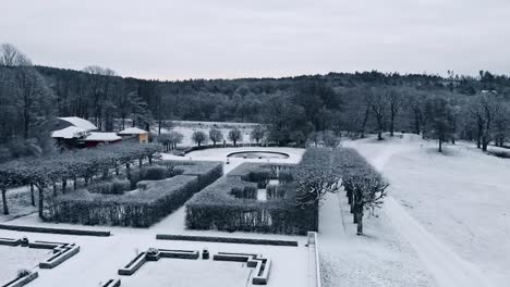 Drone-aerial-flight-past-the-Gunnebo-Palace-towards-the-snow-covered-garden