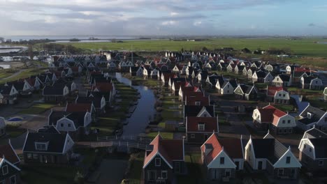 Aerial-Slowmotion-of-Small-Quiet-Dutch-Holiday-Park-during-Sunset-with-Long-Shadows-and-Countryside-in-Background