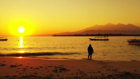 Goldener-Sonnenuntergang-über-Dem-Sandstrand-Mit-Einer-Frau,-Die-Einen-Tropischen-Urlaub-Genießt