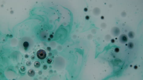 Small-dark-spots-on-a-green-and-white-liquid