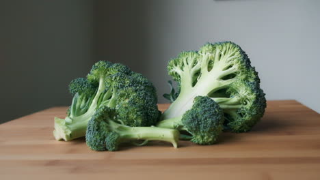 Fresh-and-Raw,-Slow-Push-In-to-Green-Broccoli-on-Light-Wooden-Butcher's-Block