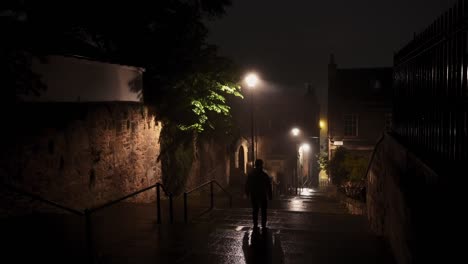 Person-walking-down-the-stairs-at-Flodden-Wall-in-Edinburgh-on-a-quiet-foggy-night