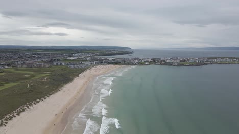 Stunning-Landscape-Of-The-Seaside-Town-And-Portrush-Whiterocks-Beach-With-Ocean-Waves-In-Portrush,-Northern-Ireland---aerial-drone