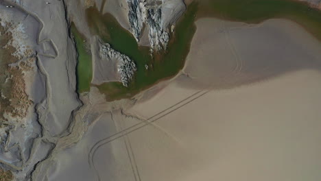 Aerial-top-down-view-of-the-coast-line-in-the-UK,-with-the-tide-out,-on-summers-day