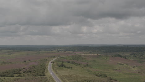 Aerial-Drone-Shot-of-English-UK-Countryside-in-The-New-Forest-with-Road-and-Cars-in-moody-stormy-weather