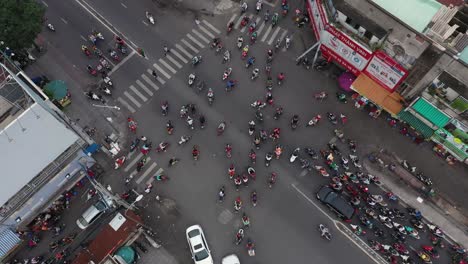 Top-down-high-angle-drone-shot-of-a-busy-intersection-watching-the-chaos-of-the-of-the-Saigon-motor-cycle-traffic