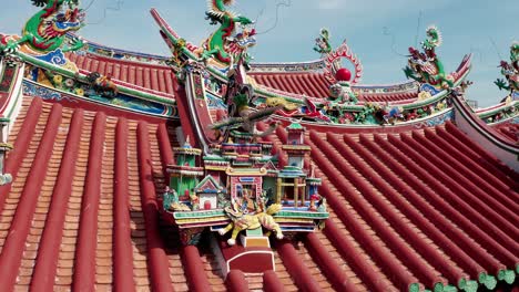 Yeoh-Kongsi-Temple-colorful-clan-homes-and-Chinese-dragon-sculptures-adorn-the-roof-area,-Aerial-orbit-around-reveal-shot