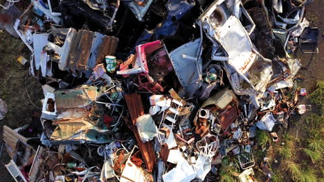 Large-pile-of-scrap-metal,-car-parts,-doors,-bumper,-among-other-remains