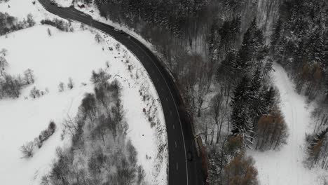 Aerial,-tilt-up,-drone-shot,-of-a-wet-road,-in-Romanian-highlands,-bad-weather,-on-a-overcast,-winter-day,-in-Romania
