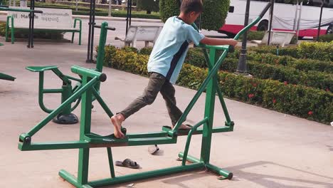 Slow-Motion-Shot-of-a-Kid-Using-Exercise-Machine-In-Park