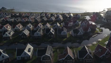Aerial-Zooming-Out-a-Small-Dutch-Holiday-Park-next-to-the-Ocean-during-Sunset-with-Nice-Long-Shadows
