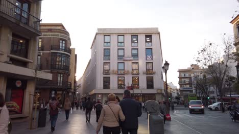 People-walking-on-crowded-streets-of-Seville-shopping-area,-Slowmo-Tilt-Up