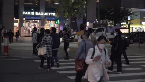Gente-Cruzando-En-El-Carril-Peatonal-En-El-Distrito-De-Gangnam,-Seúl,-Corea-Del-Sur-Por-La-Noche---Midshot