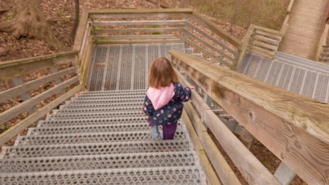 Following-a-little-girl-walking-down-an-outdoor-staircase