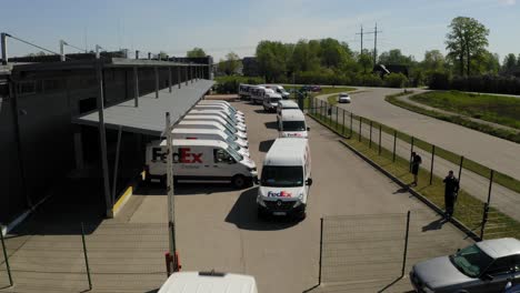 Aerial-view-on-Fedex-cars-in-a-line-driving-out-from-warehouse