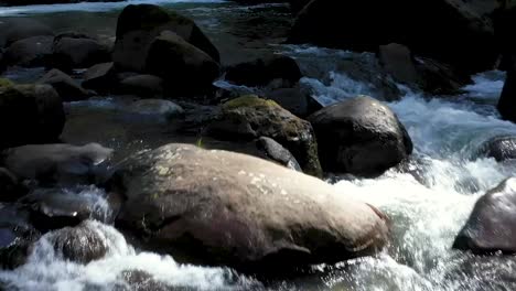 Drone-footage-flying-close-to-rocks-sticking-out-of-pristine-clean-water-below-the-falls-in-the-Coquille-River