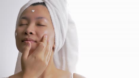 Close-up-of-a-woman-applying-a-nourishing-cream-to-the-face-for-natural-skincare