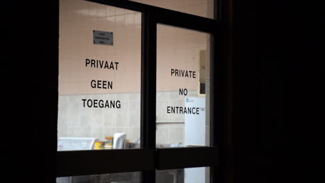 Private-no-entrance-notice-on-glass-door,-continuous-shot