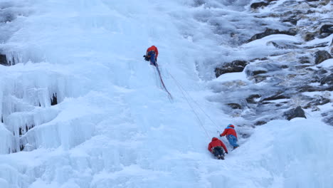 Ein-Team-Von-Eiskletterern-Bereitet-Seile-Entlang-Einer-Massiven-Eiswand-Vor