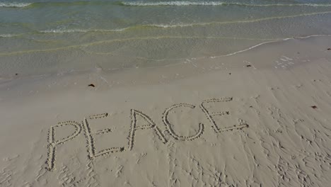 Aerial-camera-showing-PEACE-inscribed-in-the-sand-and-then-pulls-away-as-it-gets-smaller