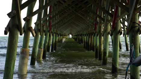 A-hammock-waves-in-the-breeze-under-the-pier-at-Folly-Beach,-South-Carolina