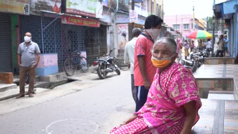 Alte-Asiatische-Arme-Frau-Und-Andere-Menschen,-Die-Während-Der-Sperrung-Des-Coronavirus-In-Indien-Masken-Tragen