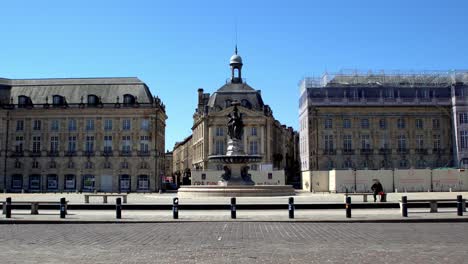 Square-of-Place-de-la-Bourse-with-cars-passing-in-front-empty-square-due-to-the-COVID-19-pandemic,-Stable-handheld-shot