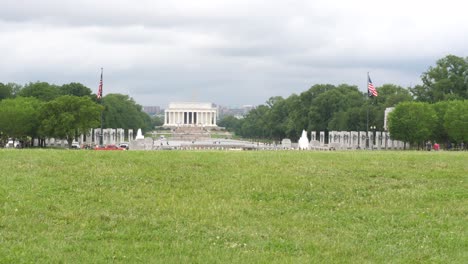 Lincoln-memorial-temple-in-distance-with-male-jogger-running-across-shot,-Washington,-D