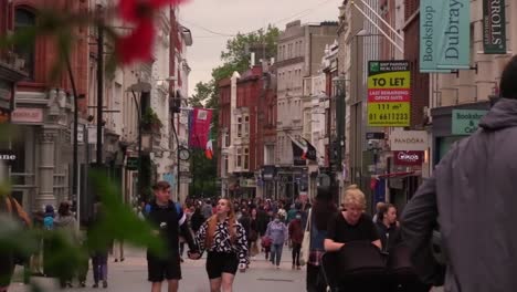 Dolly-shot-of-people-on-a-high-street-returning-to-shopping-after-lockdown