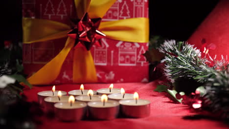 Weihnachtsdekoration-Mit-Kerzen-Und-Geschenk-Auf-Rotem-Hintergrund