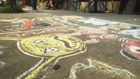 People-walking-past-sidewalk-chalk-art,-Close-Up,-Slide-Right