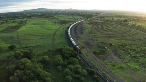 Aerial-View,-Passenger-Train-Moving-Through-Rural-Pune-In-India