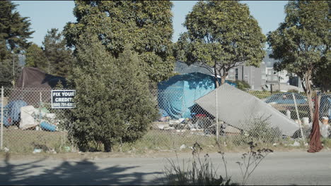 Medium-shot-of-a-homeless-camp-next-to-the-freeway-in-Berkeley,-California