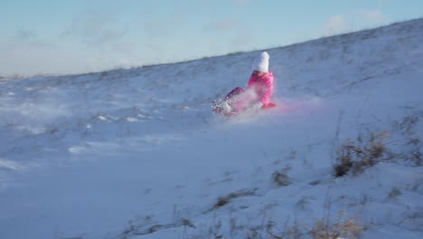 Children-are-sledding-down-on-a-snow-covered-hill