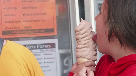Young-girl-licking-soft-serve-ice-cream-cone,-Close-Up,-Slow-Motion