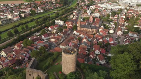 Flown-away-from-an-old-castle-ruin-in-the-background-is-the-city-Hausach,-Germany