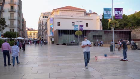 Gente-Paseando-Frente-Al-Antiguo-Teatro-Romano-En-La-Ciudad-De-Málaga,-España-Temprano-En-La-Mañana---Toma-Panorámica