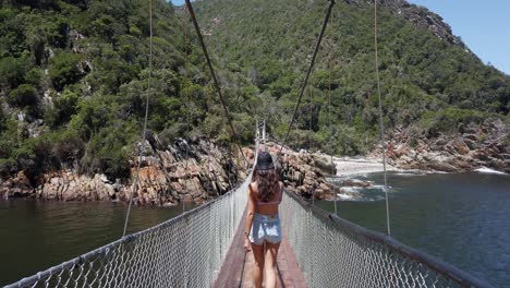 Girl-walking-on-Tsitsikamma-suspension-footbridge.-Handheld