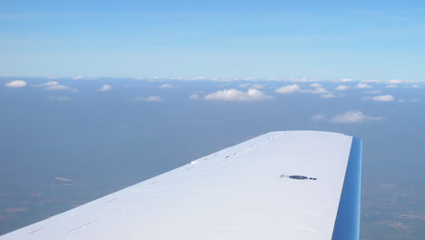 Shot-of-the-wing-of-a-private-jet-flying-through-the-sky