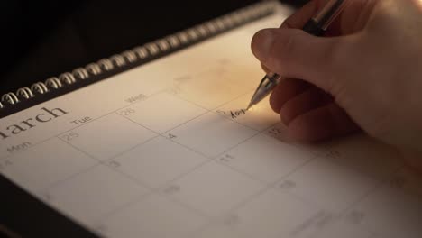 Hand-writing-reminder-for-tax-returns-in-calendar-close-up-panning-shot