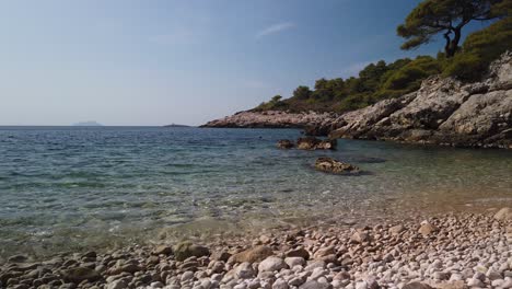 View-of-the-pebbly-Barjoska-Beach-on-the-island-of-Vis-in-Croatia-with-a-lone-snorkeler-in-the-distance