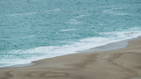 Crashing-Waves-On-Golden-Beachfront-Sands-In-Praia-do-Norte-,-Nazare,-Portugal