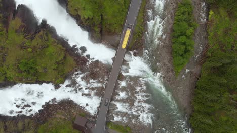 Truck-driving-over-bridge-in-Norwegian-highlands,-Latefossen-Waterfall,-aerial
