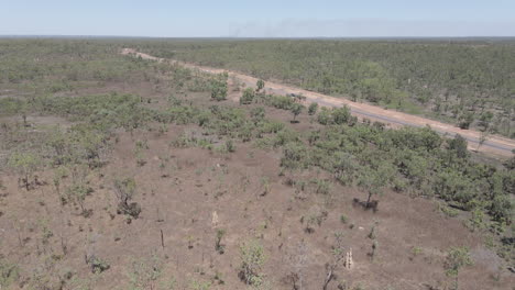 Aerial-drone-moving-shot-of-a-car-driving-on-a-long-straight-highway,-Northern-Territory